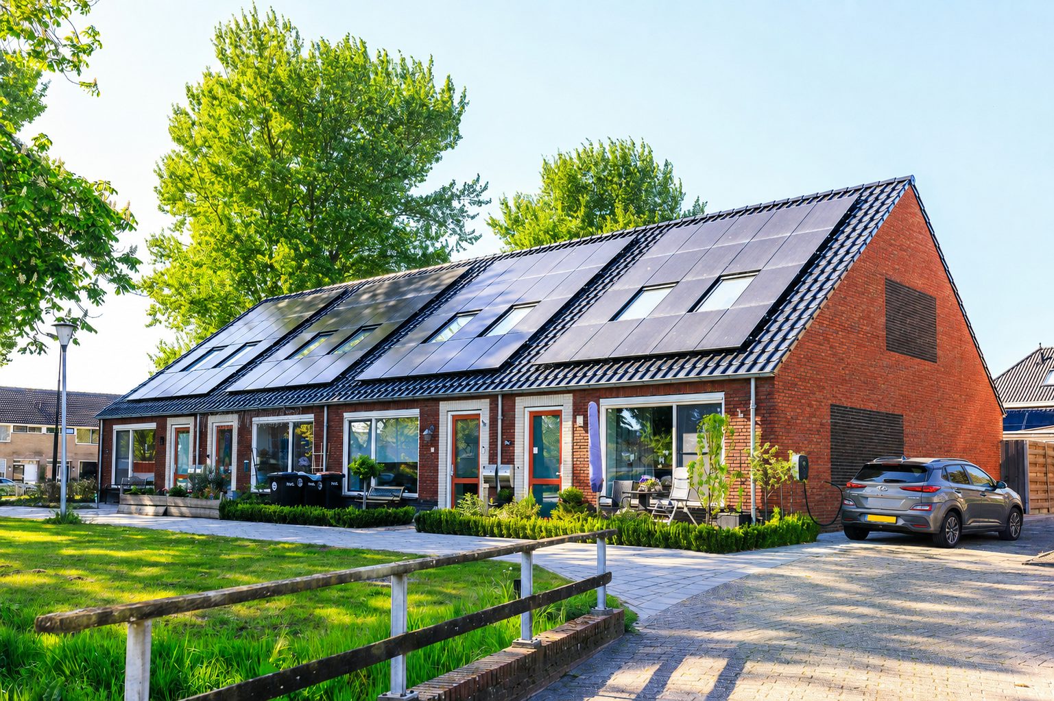 Viviendas con instalación fotovoltaica en cubierta y vehículo eléctrico cargando